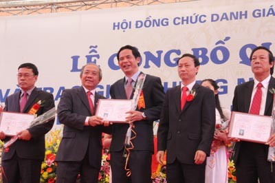 Professor Tran Van Nhung (2nd, L), General Secretary of the State Professor Title Council offers certificates to teachers