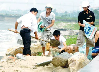 Người dân Đà Nẵng xúc cát về chèn mái nhà chống bão.