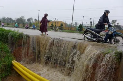 Trong nội thành, một số nơi nước lũ làm sạt đường. Ảnh: N Khôi