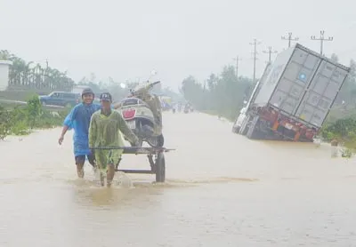 Trên các tuyến tỉnh lộ, quốc lộ bị chia cắt, xuất hiện dịch vụ "cõng" xe máy giá 50.000 đồng/lượt. Riêng các xe tải cũng nằm đường. Ảnh: N Khôi