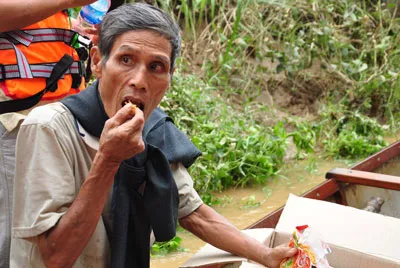 Cả đêm vật lộn với lũ, người dân vội vàng dùng ngay mì tôm khi được cứu trợ. Ảnh Hà Minh