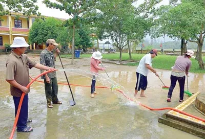 Thầy cô giáo Trường Tiểu học Ngô Quang Tám (Đại Lãnh, Đại Lộc, Quảng Nam) dọn bùn non sau lũ lụt. Ảnh: Nguyên Khôi
