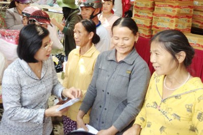 Nguyen Thi Thu Ha, Deputy Secretary of the HCMC Party Committee, gives Tet gifts to 300 flood hit victims in Hanh Minh Commune in Nghia Hanh District of Quang Ngai Province. (Photo: SGGP)