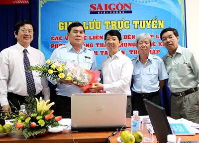 Phó TBT Báo SGGP Nguyễn Thành Lợi (giữa) tặng hoa khách mời giao lưu trực tuyến