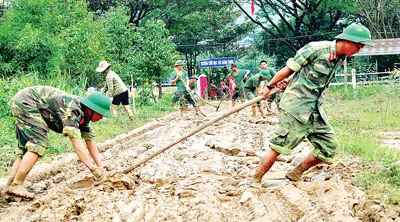 Sức người cào lớp bùn non phủ dày mặt đường dẫn vào Trường THCS Hành Thiện, huyện Nghĩa Hành.
