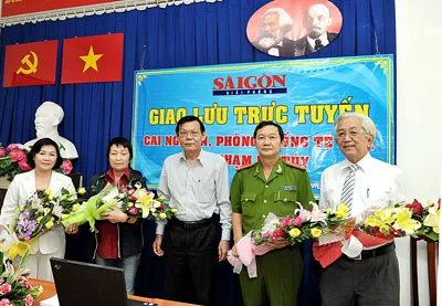 TBT Báo SGGP Nguyễn Tấn Phong (giữa) tặng hoa các vị khách mời tham gia buổi giao lưu.