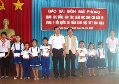 The representative of Sai Gon Giai Phong Newspaper gives scholarships to poor pupils in Phu Quoc Island. (Photo:SGGP)