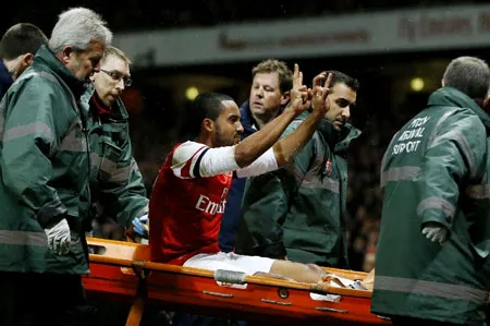 Theo Walcott rời sân bằng cáng và phản ứng của mình.