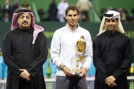 Rafael Nadal (giữa) nhận chiếc cúp vô địch đầu tiên trong năm 2014.