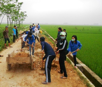 Members of the commune's Youth Communist Union join hands to build the road into the village