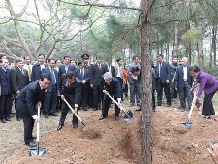 Party General Secretary Nguyen Phu Trong and representatives of sectors plant a banyan tree on Dong Vang hill in the capital city's Ba Vi District. — Photo Tri Dung