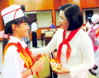 Vice Secretary of the municipal Party Committee Nguyen Thi Thu Ha li xi (gives lucky money on Tet holidays) to children in the meeting.