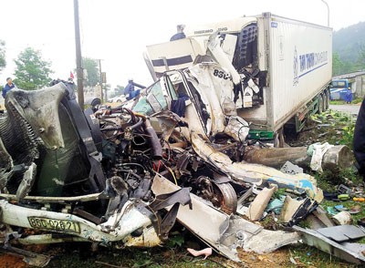 A passenger bus collides with a container truck leaving two dead and ten injured in Ha Tinh Province on February 12 (Photo: SGGP)