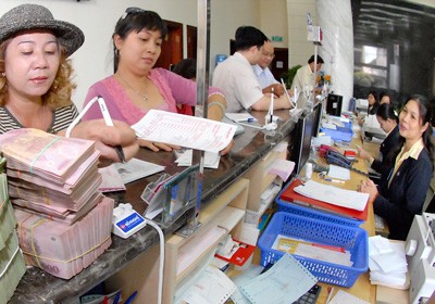 Customers deposit money at a bank in HCMC (Photo: SGGP)