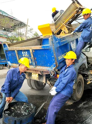 Chuyển rác từ cống lên trên đường Hồng Lạc, quận Tân Phú.