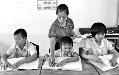 Cô Ngọc Điệp hướng dẫn các em học sinh lớp 1C tập đọc.