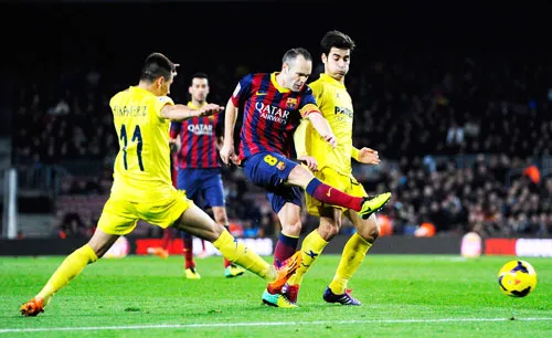 Iniesta (Barcelona) tung cú sút giữa hàng phòng ngự Villarreal ở lượt đi.