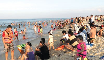 People are hiting the beaches in numbers in Quang Binh, Quang Tri and Ha Tinh Provinces as they seek relief from the scorching weather (Photo: SGGP)