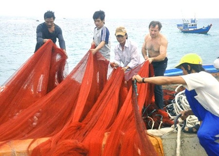 A friend of Viet Nam: Andre Menras (bare chested) goes fishing with Ly Son islanders. A documentary about him will be screened for Ha Noi audiences. — Photo vnexpress.net