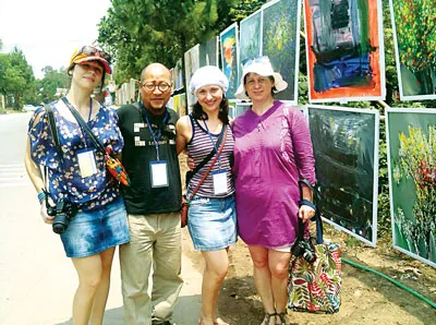 Họa sĩ Nguyễn Duy Hiền (giữa) chụp ảnh lưu niệm cùng các họa sĩ thế giới tại phố tranh trên đường Lê Ngô Cát.