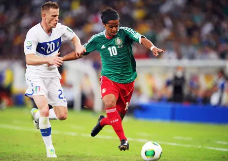 Tiền đạo Giovani dos Santos (phải, Mexico) vượt qua Ignazio Abate (Italia).