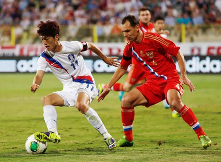 Lee Chung-Yong (Hàn Quốc, trái) đi bóng trước Sergei Ignashevich (Nga).