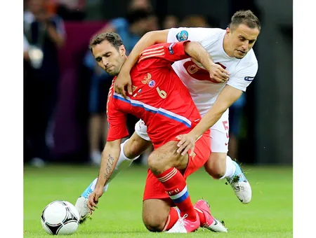 Tiền vệ Roman Shirokov (Nga, trái) trong pha tranh bóng với hậu vệ Ba Lan.