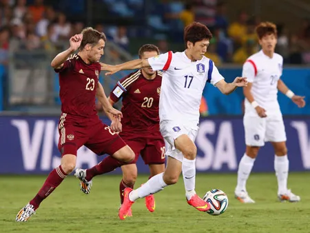 Tiền vệ Lee Chung-Yong đi bóng trước hàng phòng ngự tuyển Nga.