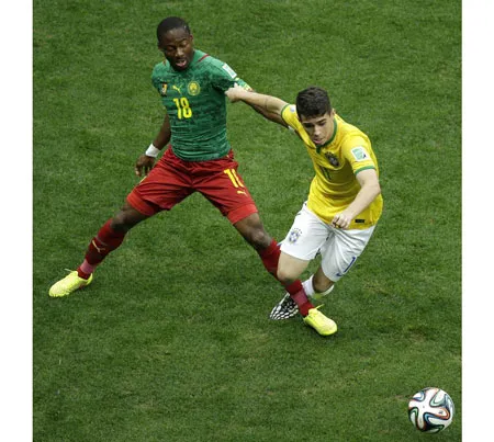 Oscar đi bóng trước sự đeo bám của cầu thủ Cameroon.