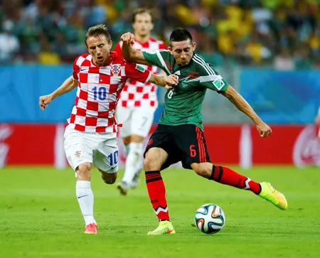 Pha sút bóng của Herrera (Mexico) trước sự đeo bám của Modric (Croatia).
