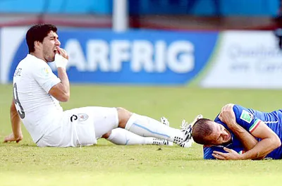 Chiellini (phải, Italia) tỏ vẻ đau đớn sau pha “cẩu xực” của Suarez.