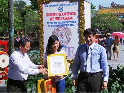 The lucky tourist Ho Mai Phuong (middle) is given awards of number one millionth visitor to Hue Relic Site (Photo:SGGP)
