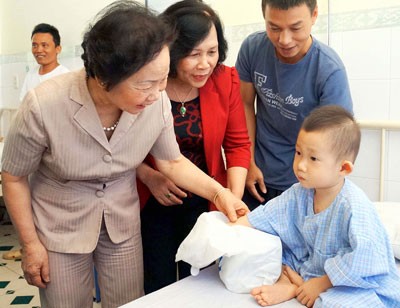 Vice President Nguyen Thi Doan presents gift to a child at the hospital (Photo: SGGP)