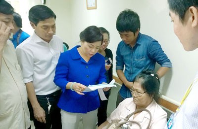 Health Minister Nguyen Thi Kim Tien ( in blue shirt) talks to a patient in Medical University Hospital in the surprise visit (Photo: SGGP)