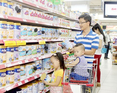 Consumers are choosing dairy products in a supermarket (Photo: SGGP)