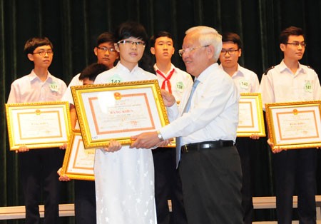 HCMC People's Committee chairman Le Hoang Quan gives certificates of merit to good students (PHoto: SGGP)