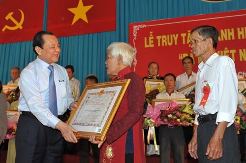 HCM City's Party Committee Secretary Le Thanh Hai awards the Heroic Vietnamese Mothers title to a mother’s relatives. (Photo: Sggp)