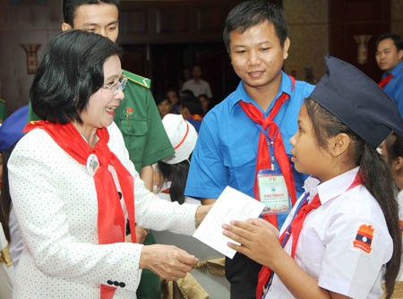 Deputy Secretary of the HCMC Party Committee Nguyen Thi Thu Ha gifts Lao children at the meeting(Photo:SGGP)