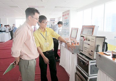 Hung Phu Automation Company staff (R) introduces industrial automation products to a customer (Photo: SGGP)