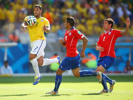 Tiền đạo Hulk (trái, Brazil) bứt qua hàng phòng thủ Chilê