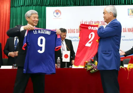 Chủ tịch VFF Lê Hùng Dũng (phải) trao đổi áo lưu niệm với đại diện LĐBĐ Nhật trong buổi ký kết.