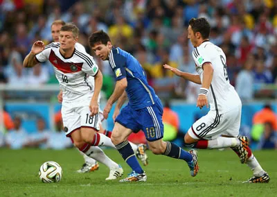 Các tiền vệ Toni Kroos (trái) và Mesut Oezil bám sát Lionel Messi (Argentina).