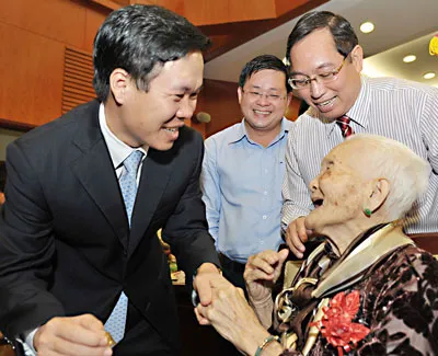 Phó Bí thư Thường trực Thành ủy TPHCM Võ Văn Thưởng chúc mừng mẹ Nguyễn Thị Thiếp được trao tặng danh hiệu Bà mẹ Việt Nam anh hùng. Ảnh: VIỆT DŨNG