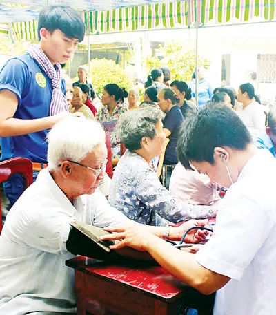 Y bác sĩ Bệnh viện Điều dưỡng - Phục hồi chức năng - Điều trị bệnh nghề nghiệp TPHCM khám bệnh cho đối tượng diện chính sách tại Bình Chánh ngày 26-7.