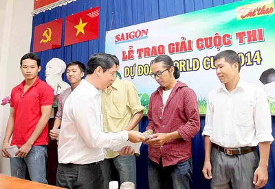 Ông Nguyễn Thành Lợi, Phó Tổng biên tập Báo SGGP trao giải cho bạn đọc đoạt giải cuộc thi Dự đoán World Cup 2014. Ảnh: DŨNG PHƯƠNG