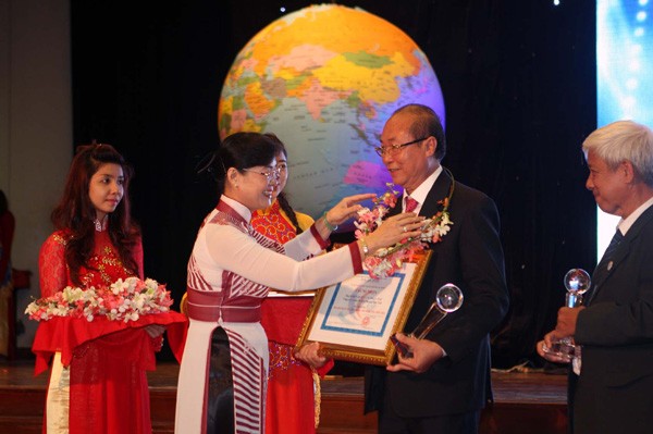 Chairwoman of the city People’s Council Nguyen Thi Quyet Tam offers certificates of merits to entrepreneurs (Photo: SGGP)