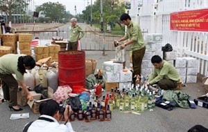 Staff from Da Nang's Market Watchdog Department destroy counterfeit goods (Photo: VNA