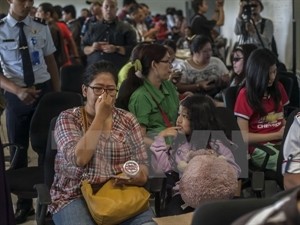 Families and relatives of the passangers on the missing AirAsia flight QZ8501 are waiting for news at the Juanda airport. (Photo: AFP/VNA)
