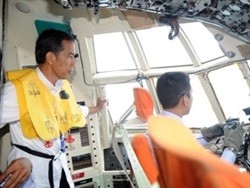Indonesian President Joko Widodo (left) stands in the cockpit of a Hercules C-130 during the search operation for missing AirAsia flight QZ8501. – Photo AFP/VNA