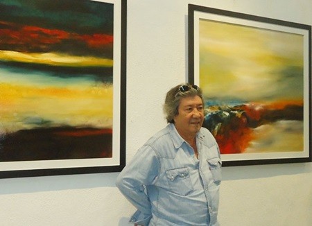 Techniques and pigments: French-Vietnamese artist Robert Mihagui with his works at the exhibition. — VNS Photo Sunny Rose